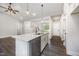 Bright kitchen island with stainless steel dishwasher and faucet, and view to living room at 702 Tuscany Cir, Princeton, NC 27569