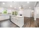 Kitchen island with stainless steel dishwasher and faucet, view to living room and fireplace at 702 Tuscany Cir, Princeton, NC 27569