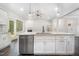 Kitchen island with stainless steel dishwasher and faucet, view to living room and fireplace at 702 Tuscany Cir, Princeton, NC 27569