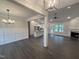 Spacious living room with elegant lighting, wood floors, and a cozy fireplace, flowing into the open kitchen at 702 Tuscany Cir, Princeton, NC 27569