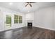 Light-filled living room showcasing a cozy fireplace, hardwood floors, and a door to the backyard at 702 Tuscany Cir, Princeton, NC 27569