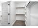 A well-organized walk-in closet with built-in shelving and hanging rods offers ample storage space at 702 Tuscany Cir, Princeton, NC 27569