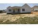 Exterior of new home with white siding, covered porch, and a spacious yard ready for landscaping at 71 Royal Ave, Selma, NC 27576