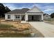 New construction featuring a two-car garage, stone accents, and a covered porch at 71 Royal Ave, Selma, NC 27576