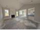 Open-concept living room with fireplace, wainscoting, and plenty of natural light at 71 Royal Ave, Selma, NC 27576