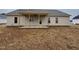 New construction house with a beige vinyl exterior and covered porch in the backyard at 76 Royal Ave, Selma, NC 27576