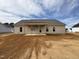 View of the back of the house with a porch, surrounded by dirt at 76 Royal Ave, Selma, NC 27576