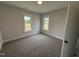 Empty bedroom with carpeted floor and view to the outdoors through two windows at 76 Royal Ave, Selma, NC 27576