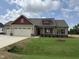Charming single-Gathering home boasts a two-car garage, beautiful lawn and appealing exterior with red accents at 76 Royal Ave, Selma, NC 27576
