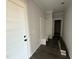 Hallway featuring wood floors, a coat rack bench and white trim at 76 Royal Ave, Selma, NC 27576