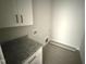 Utility room featuring granite countertops, white cabinets, and tile floors at 76 Royal Ave, Selma, NC 27576