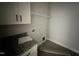 Laundry room with tile floor, granite countertop, and overhead shelving at 76 Royal Ave, Selma, NC 27576