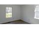 Bedroom showcasing gray flooring, neutral paint, and generous natural light through the windows at 7605 Mine Valley Rd, Raleigh, NC 27615