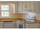 Well-lit kitchen with white cabinets, wooden countertops, and an electric range stove at 7605 Mine Valley Rd, Raleigh, NC 27615