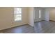 Living room with gray floors, neutral paint, white trim, and natural light from the large windows at 7605 Mine Valley Rd, Raleigh, NC 27615