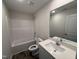 Well-lit bathroom featuring vinyl flooring, tub-shower, and a single sink vanity with quartz countertops at 8 W Emily Gardens Dr, Selma, NC 27576