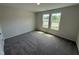 A carpeted bedroom features a pair of double hung windows offering plenty of natural light at 8 W Emily Gardens Dr, Selma, NC 27576