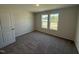A carpeted bedroom with two windows providing natural light and neutral paint throughout at 8 W Emily Gardens Dr, Selma, NC 27576