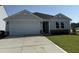 Charming single-story home featuring a two-car garage, stone accents, and a well-maintained front lawn at 8 W Emily Gardens Dr, Selma, NC 27576