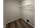 Functional laundry room with wood-look flooring and overhead shelving at 8 W Emily Gardens Dr, Selma, NC 27576