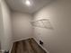 Functional laundry room with vinyl flooring, washer hookups, and a wire rack shelf for efficient organization at 8 W Emily Gardens Dr, Selma, NC 27576