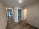 Hallway with wood-look flooring, and white doors leading to various rooms within the house at 8 W Emily Gardens Dr, Selma, NC 27577