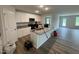 Bright kitchen featuring white cabinets, granite countertops, stainless steel microwave, and an island with a sink at 8 W Emily Gardens Dr, Selma, NC 27577