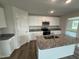 Modern kitchen boasting white cabinets, granite countertops, stainless steel appliances, and an island at 8 W Emily Gardens Dr, Selma, NC 27577