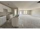Bright kitchen featuring white cabinets, unfinished island and countertops, with an adjacent living area at 8 W Emily Gardens Dr, Selma, NC 27577