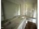 Bright bathroom featuring a double sink vanity, large mirror and a shower-tub combo at 82 W Emily Gardens Dr, Selma, NC 27576