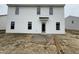 Backyard of a two-story home featuring a patio and white vinyl siding with neatly arranged windows at 82 W Emily Gardens Dr, Selma, NC 27577