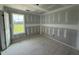 A new bedroom showcasing drywall-covered walls, trimmed windows allowing natural light, and unfinished plywood flooring at 82 W Emily Gardens Dr, Selma, NC 27577