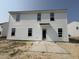 Two-story home highlighting the rear exterior with white siding, black trimmed windows, and an unfinished concrete patio at 82 W Emily Gardens Dr, Selma, NC 27577