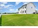 View of a two-story home's backyard, complete with a spacious, well-maintained lawn at 83 W Emily Gardens Dr, Selma, NC 27576