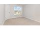 A carpeted bedroom is brightened by a window that offers a view of the neighborhood at 83 W Emily Gardens Dr, Selma, NC 27576