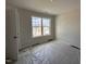 Well-lit bedroom with a large window showcasing neighborhood views and neutral walls at 83 W Emily Gardens Dr, Selma, NC 27576
