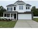 Charming two-story home featuring a two-car garage and a welcoming front porch at 83 W Emily Gardens Dr, Selma, NC 27576