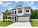 Inviting two-story home with a two-car garage, stone accents, and a manicured lawn at 83 W Emily Gardens Dr, Selma, NC 27576