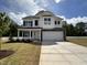 Beautiful two-story home with a covered porch, two-car garage, and a well-manicured front yard at 83 W Emily Gardens Dr, Selma, NC 27576