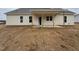 New construction home featuring a covered back porch with a foundation and a spacious, unfinished backyard at 87 Tee Dr, Selma, NC 27576