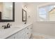 Bathroom with double sinks, quartz countertops, framed mirrors, and tile flooring at 87 Tee Dr, Selma, NC 27576