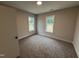 Cozy bedroom featuring plush carpeting, neutral walls, and natural light from two windows at 87 Tee Dr, Selma, NC 27576