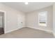 This bedroom features carpet, neutral walls, a large window, and closet with double doors at 87 Tee Dr, Selma, NC 27576