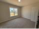 Bedroom features neutral carpet, natural light from the window, and a closet at 87 Tee Dr, Selma, NC 27576