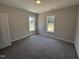Cozy bedroom featuring neutral walls, carpeted floor, and two windows offering natural light at 87 Tee Dr, Selma, NC 27576