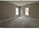 Empty bedroom with bare concrete flooring and large windows offering natural light at 87 Tee Dr, Selma, NC 27576