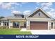 Charming single-Gathering home with a stone-accented facade, two-car garage, and well-manicured lawn at 87 Tee Dr, Selma, NC 27576