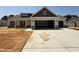 Newly constructed home with a two-car garage and neutral-toned siding accented by stone and dark brown trim at 87 Tee Dr, Selma, NC 27576