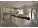 Bright, partially constructed kitchen with white cabinets, an island, and natural light at 87 Tee Dr, Selma, NC 27576