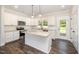 Modern kitchen with white cabinets, stainless steel appliances, and a center island with granite countertop at 87 Tee Dr, Selma, NC 27576